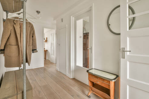 Interior of hallway with coat rack and white doors leading to different rooms in contemporary house - ADSF48712