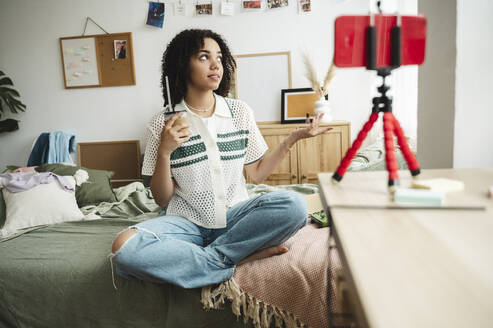 Teenager-Influencerin, die zu Hause einen Vlog über ihr Smartphone führt - ALKF00702