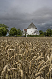 Dänemark, Bornholm, Nylars, Gewitterwolken über dem Feld vor der Nylars Kirche - KEBF02756