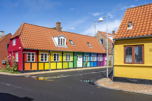 Dänemark, Bornholm, Ronne, Leere Straße vor einem regenbogenfarbenen Haus - KEBF02757