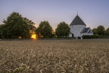 Dänemark, Bornholm, Nylars, Feld vor der Nylars Kirche bei Sonnenuntergang - KEBF02762