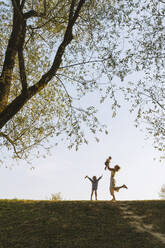 Happy mother playing with children at park - NDEF01279