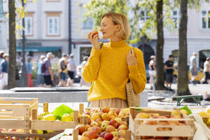 Frau riecht an frischen Äpfeln auf dem Bauernmarkt - NDEF01298