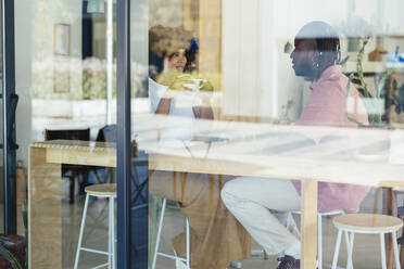 Happy couple having coffee and talking at cafe - EBSF04013