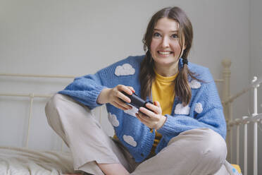 Glückliches Mädchen spielt Videospiel mit Controller zu Hause - IHF01806