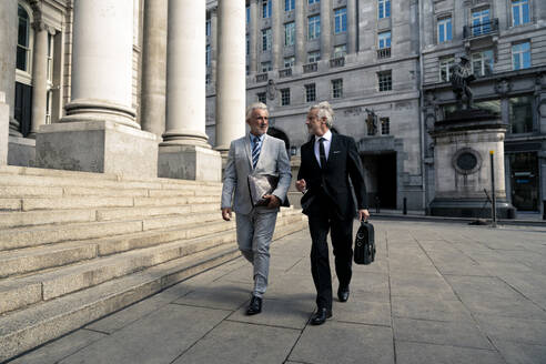 Businessmen walking together near financial buildings - OIPF03585