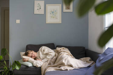 Gestresste Frau schläft auf dem Sofa zu Hause - SVKF01693