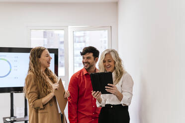 Multirassische Kollegen lachen im Besprechungsraum im Büro - PBTF00376