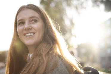 Happy young woman with long hair in sunlight - AMWF01955