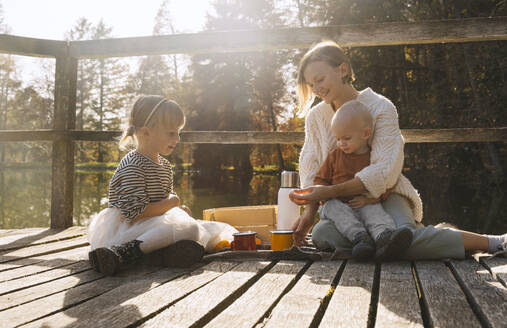 Glückliche Mutter verbringt ihre Freizeit mit Kindern auf einer Fußgängerbrücke - NDEF01337