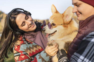 Pärchen mit Hund und Sonnenbrille im Park am Wochenende - VBUF00485