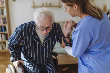 Home caregiver assisting senior man at home - HAPF03355