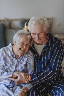 Happy senior woman holding hands with man at home - HAPF03362