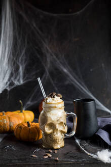 Schädelförmiger Becher mit Kürbisgewürz-Latte mit Schlagsahne und karamellisierten Kürbiskernen - SBDF04663