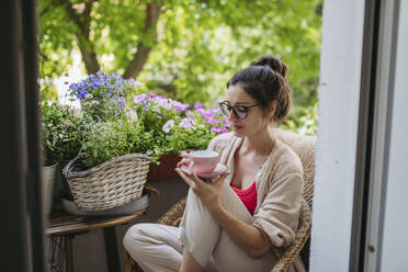 Woman enjoying her free time and a cup of coffee on the balcony - HAPF03404