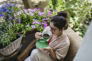 Woman enjoying her free time and a cup of coffee on the balcony - HAPF03408