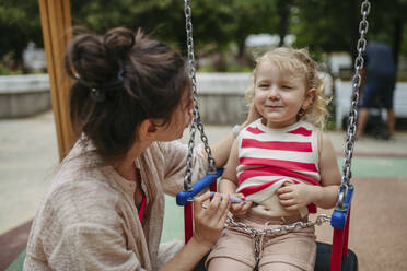 Mother giving her toddler daughre an insulin injection on the playgound - HAPF03439