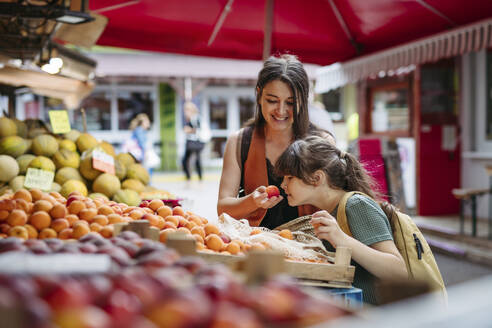 Mutter und Tochter beim Einkaufen von frischem Obst und Gemüse auf dem Stadtmarkt - HAPF03453