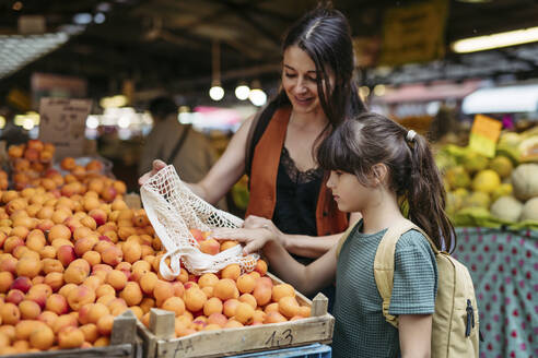 Mutter und Tochter beim Einkaufen von frischem Obst und Gemüse auf dem Stadtmarkt - HAPF03454