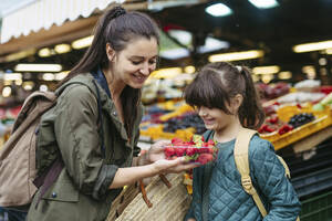 Mutter und Tochter beim Einkaufen von frischem Obst und Gemüse auf dem Stadtmarkt - HAPF03459