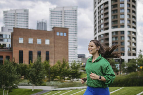 Beautiful woman jogging through the city park - HAPF03464