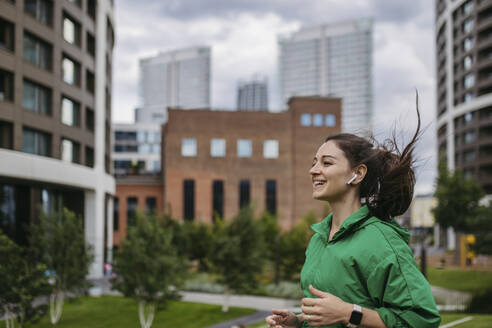 Beautiful woman jogging through the city park - HAPF03465