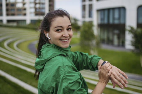 Beautiful woman exercising in a city park checking her performance on smart watch - HAPF03475