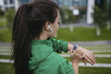 Beautiful woman exercising in a city park checking her performance on smart watch - HAPF03476