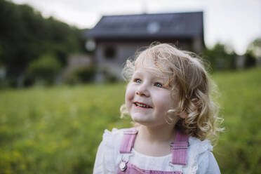 Cute little girl in front her family house - HAPF03495