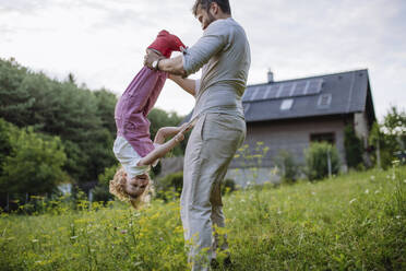 Father and little daughter having fun in front their family house - HAPF03496