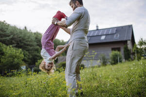 Father and little daughter having fun in front their family house - HAPF03496