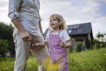 Father and daughter playing in the garden of their home - HAPF03497