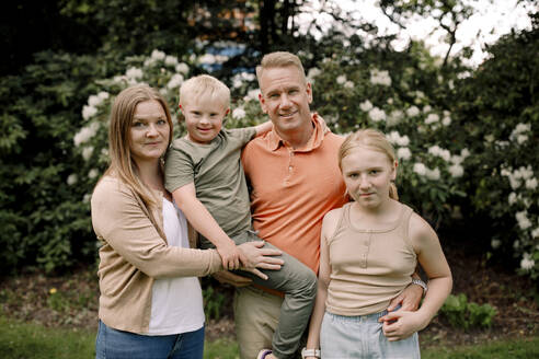 Porträt einer lächelnden Familie im Park - MASF40354