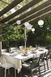 Lanterns hanging over dining table at patio - MASF40362