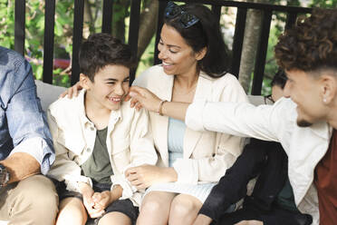 Happy family sitting together at patio in back yard - MASF40372