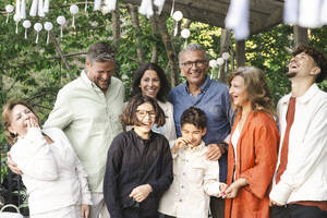 Fröhliche Familie und Freunde auf der Terrasse beim Mittsommerfest - MASF40397