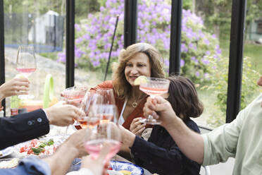 Family toasting while enjoying dinner party - MASF40431
