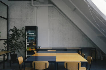 Empty dining table near refrigerator at office cafeteria - MASF40516