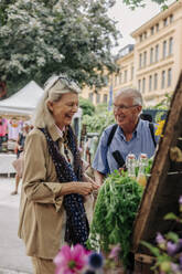 Happy senior couple at farmer's market in city - MASF40568