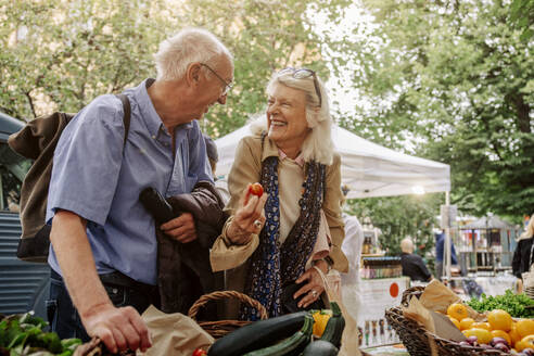 Cheerful senior woman and man enjoying at market - MASF40574