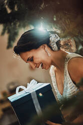 Lächelnde Frau mit Weihnachtsgeschenk zu Hause - MFF09440