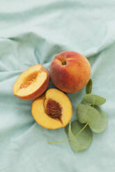 Ripe peaches on green fabric - ONAF00663