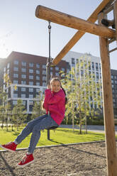 Mädchen spielt auf einer Schaukel auf dem Spielplatz - LESF00502