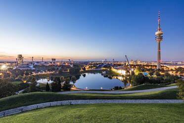 Germany, Bavaria, Munich, Olympic Park at dusk with Olympic Tower, BMW Building and pond in background - WDF07445