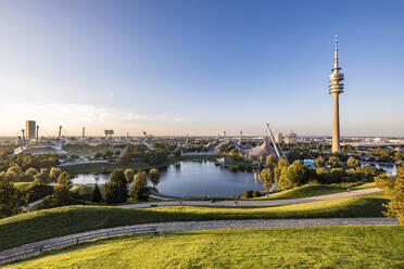 Germany, Bavaria, Munich, Olympic Park at dusk with Olympic Tower, BMW Building and pond in background - WDF07446