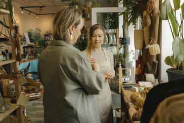 Woman helping customer to shop in zero waste store - VIVF01154