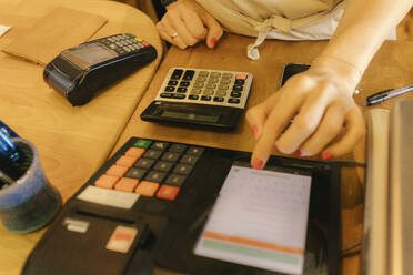 Saleswoman working at checkout counter in zero waste store - VIVF01219