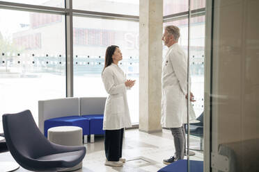 Doctors having discussion in laboratory lobby - JOSEF21886