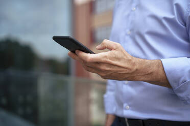 Businessman using mobile phone on balcony - JOSEF22013