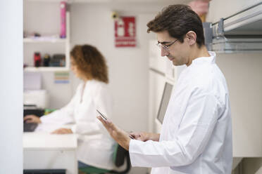 Apotheker mit Tablet-PC in der Apotheke - JSMF02895